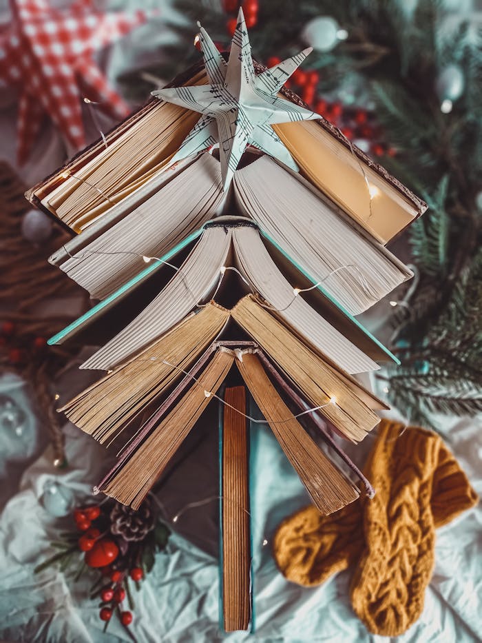 Vertical shot of a creative Christmas tree arrangement using stacked books with festive decorations.
